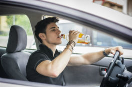young man drinking while driving