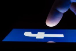finger hitting facebook icon