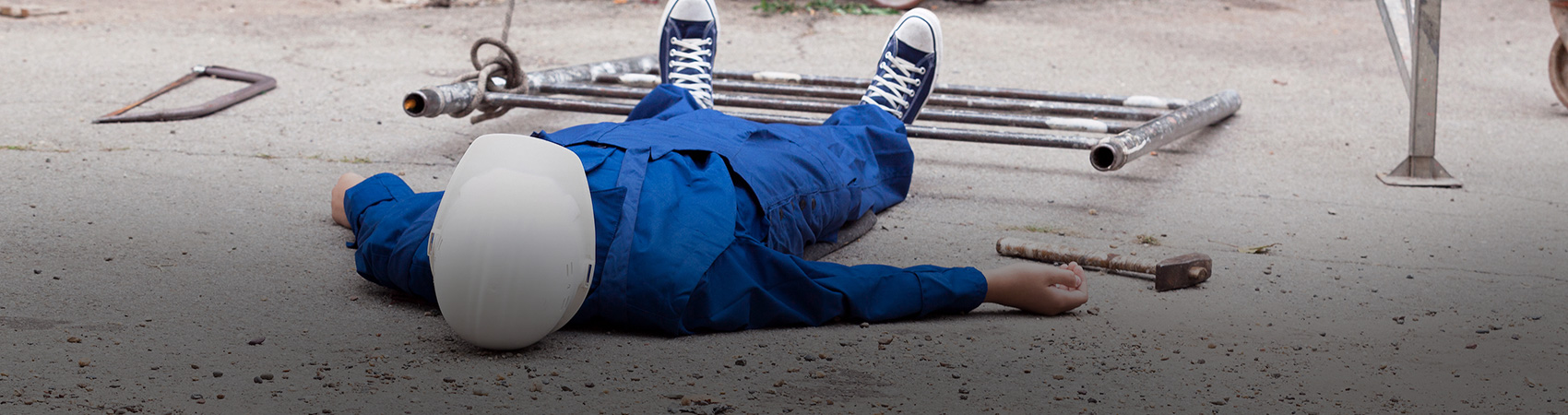 A construction worker lying down after an accident in a construction site