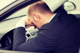tired driver holding his head