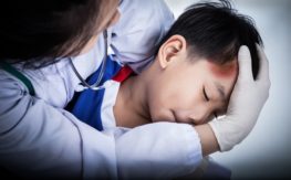 child injured in the head held by doctor