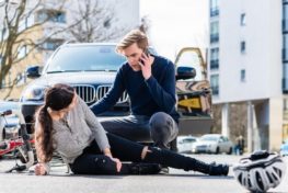 Woman injured in a bike accident with a car in San Antonio being comforted by a man on a phone