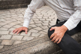 senior man grabbing knee after falling