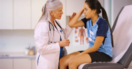 injured girl soccer player talking to woman doctor