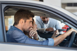 car salesman showing customer new car features