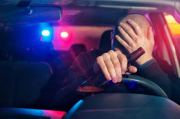 A Drunk Driver holding a bottle of alcohol