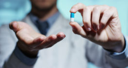 hand of a hospital medical expert shows the pill to be taken to his patient. concept of generical pills H