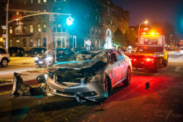 wrecked silver car at intersection nighttime