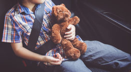 happy little girl wearing seatbelts in car