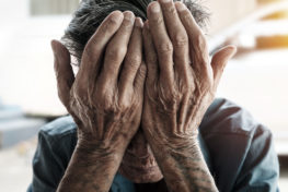 senior man covering his face with his hands.vintage tone