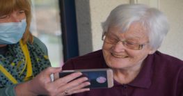 an elderly woman looking on a phone