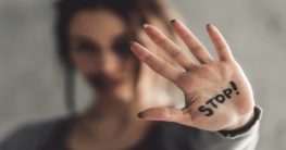 woman with the word "stop" written on her hand trying to stop abuse