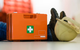 First aid medkit next to injured construction worker