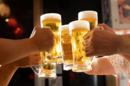 a group of friend tossing a glass full of beer